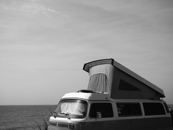 Motor home by sea against sky