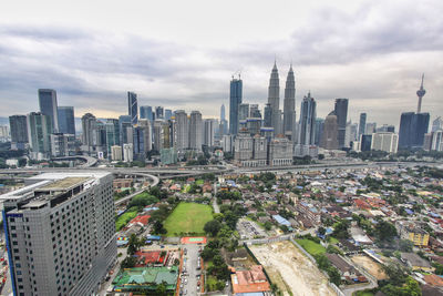 Aerial view of cityscape against cloudy sky