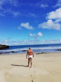 Full length of shirtless man on beach