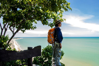 Side view of man wearing hat looking at sea