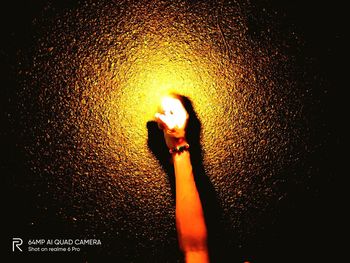 Close-up of woman standing against illuminated wall