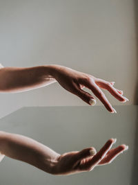 Close-up of woman hand reflection over white background