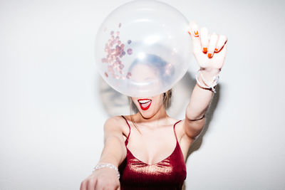 Midsection of woman holding crystal ball against white background