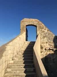 Low angle view of steps against blue sky