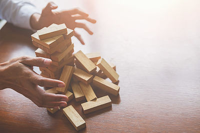 Midsection of businesswoman with wooden blocks on desk in office