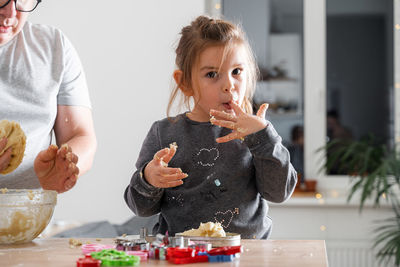 Father feeling playful with his caucasian little daughter, while preparing homemade dough 