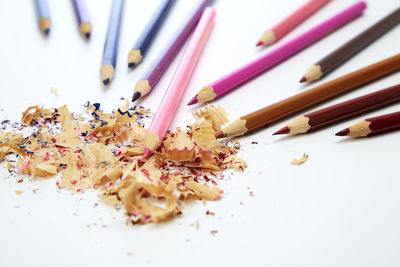High angle view of multi colored pencils on white background