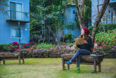 Woman sitting on bench in park