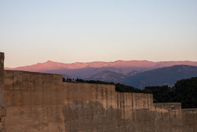 Scenic view of mountains against clear sky during sunset