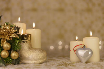 Close-up of christmas decorations with illuminated candles on table