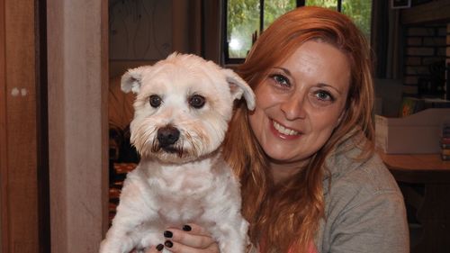 Portrait of smiling woman with dog at home