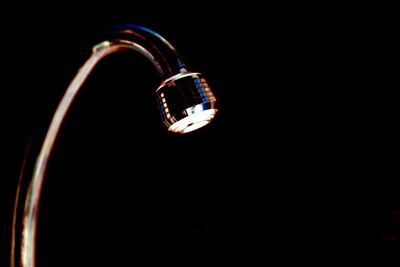 Close-up of illuminated lighting equipment against black background