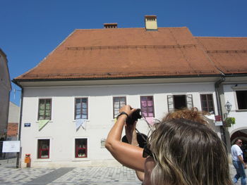 Rear view of friends against buildings