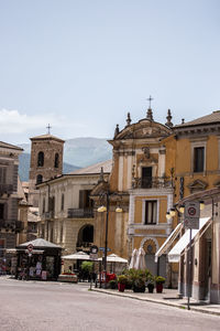 Street amidst buildings in town against sky