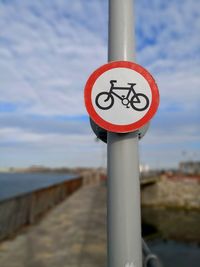 Close-up of road sign against the sky