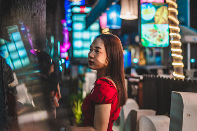 Side view of thoughtful young woman standing in restaurant