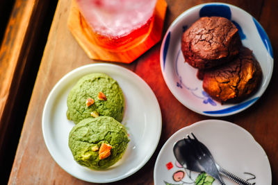 White chocolate matcha and chocolate brownie brownies cookies in plate and iced red soda.