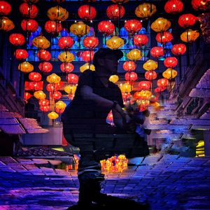 Rear view of woman standing against illuminated building