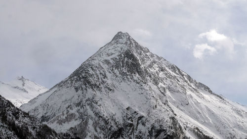 Low angle view of snowcapped mountains against sky