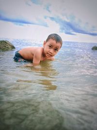 Portrait of shirtless boy in sea