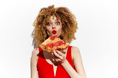 Portrait of young woman wearing santa hat against white background