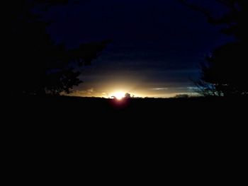 Scenic view of silhouette field against sky at sunset