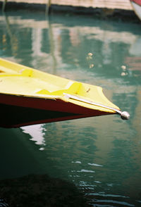 Close-up of yellow boat moored in lake