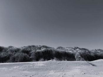 Scenic view of land against clear sky during winter