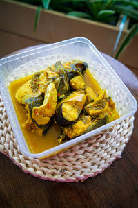 River fish pangasius sutchi, malaysia tradisional food ikan patin tempoyak in a takeaway container.