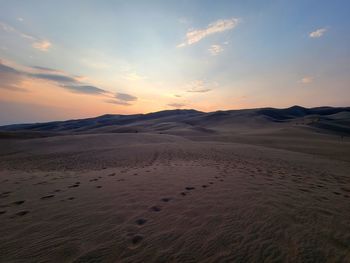 Scenic view of desert against sky during sunset