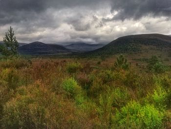 Scenic view of mountains against cloudy sky