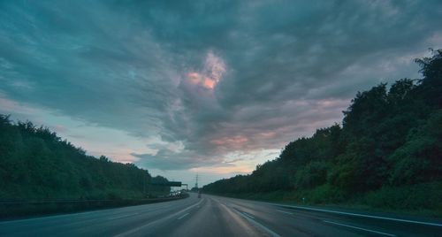 Road by trees against sky