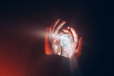 Close-up of hand holding illuminated glass