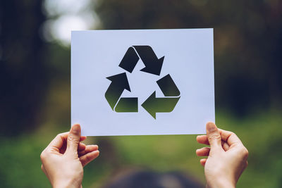 Midsection of person holding paper