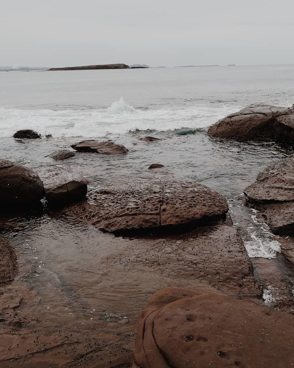 ROCKS ON SHORE AGAINST SKY