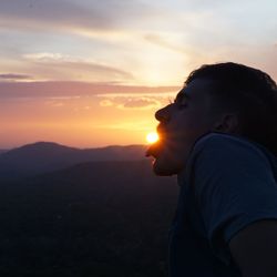 Close-up of beautiful woman against sunset sky