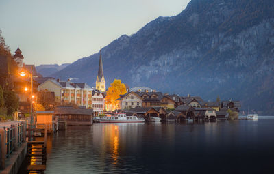 Buildings by river against sky