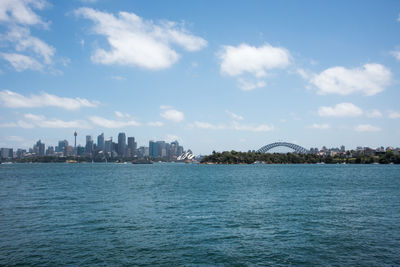 Scenic view of sea by buildings against sky