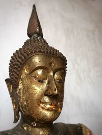 Close-up of buddha statue against building