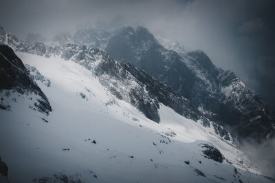 Scenic view of snow covered mountains against sky