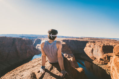 Man standing on rock against clear sky