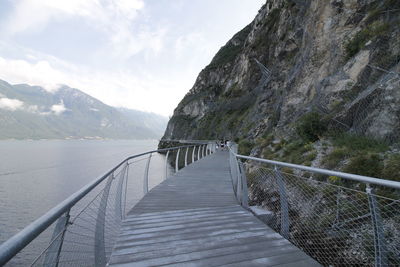 Footbridge over mountains against sky