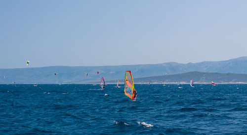 Man surfing in sea against clear sky