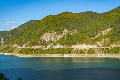 Scenic view of lake by mountains against sky