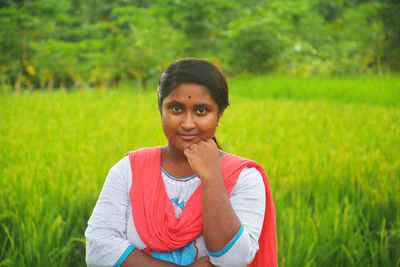 Portrait of young woman standing on field