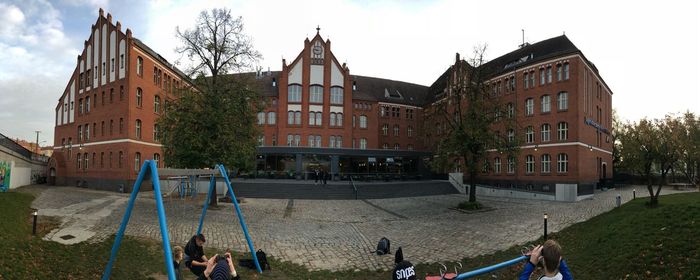 People playing in playground against buildings in city