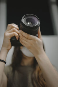 Selective focus young woman photographer using a camera