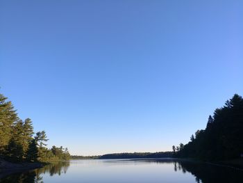 Scenic view of lake against clear blue sky