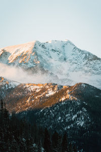 Aerial view of snowcapped mountains against clear sky