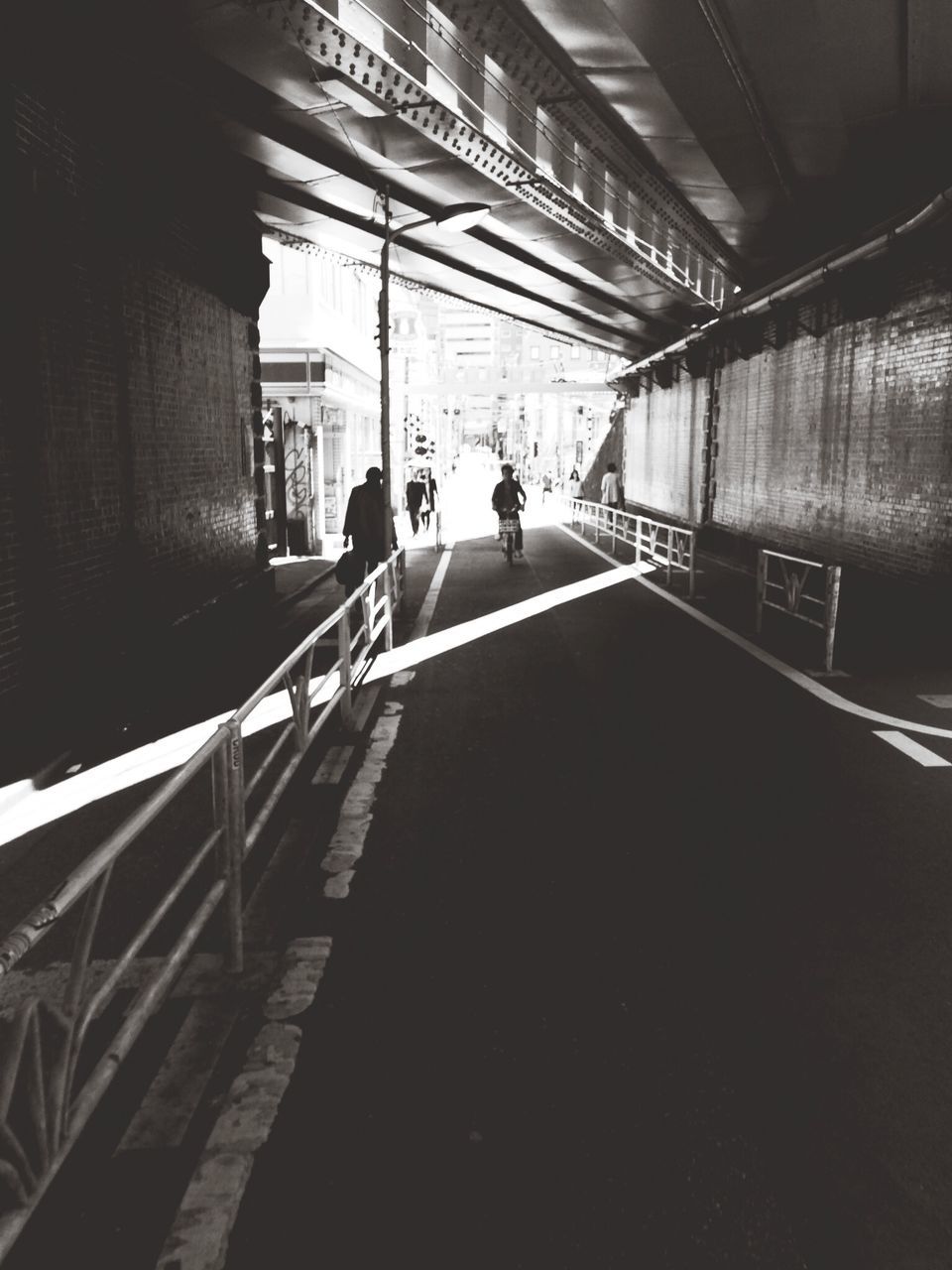 indoors, men, architecture, walking, built structure, the way forward, lifestyles, person, rear view, diminishing perspective, full length, railing, leisure activity, subway, ceiling, corridor, vanishing point